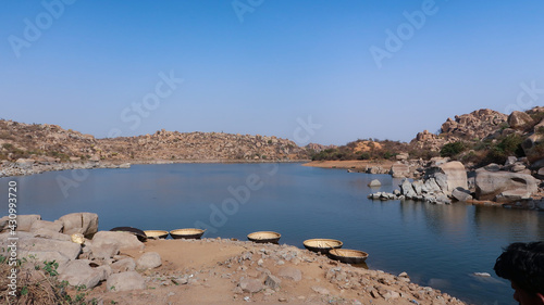 Φωτογραφία Scenic coracle ride on the Tungabhadra River in Hampi offers stunning views of rocky landscapes, ancient ruins, calm waters, and the timeless beauty of Karnataka’s heritage