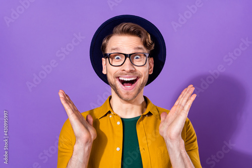 Photo of young man amazed shocked surprised omg wow happy positvie smile sale isolated over purple color background photo