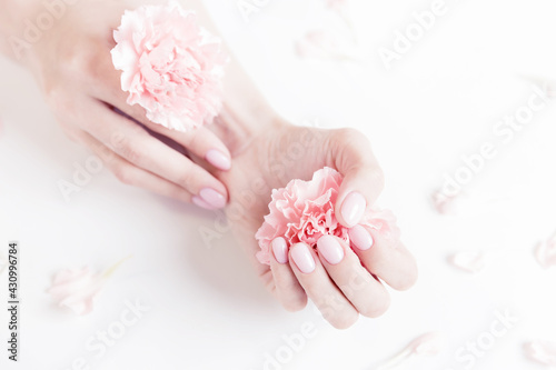 Beautiful stylish trendy woman pink manicure with flower on white background, top view. Concept beauty organic care spa
