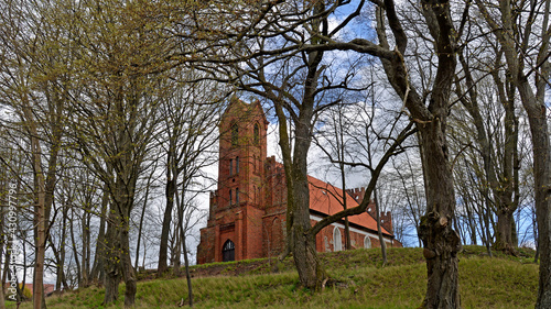 Built at the end of the 14th century in the Gothic style of red brick and stones, St. John's Catholic Church in the village of Czerniki in Masuria, Poland. The photos show a general view of the temple