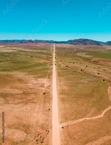 Aerial view of straight road driving into the desert in Tirasberg Conservancy park, Karas Region, Namibia. photo