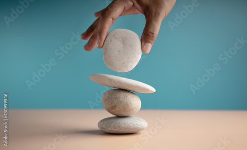 Life Balance Concept. Hand Setting White Natural Zen Stone Stack. Balancing Mind, Soul and Spirit. Mental Meditation Practice photo