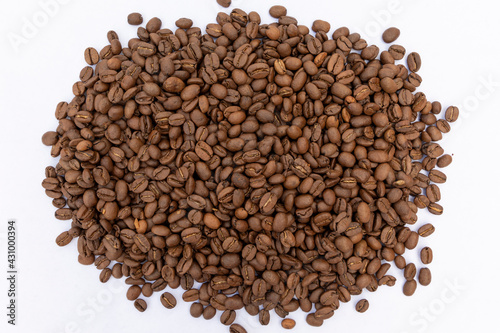A pile of roasted coffee beans against a white background