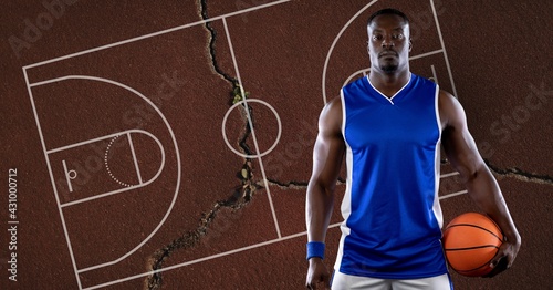 Composition of basketball player holding ball over basketball court and cracked surface