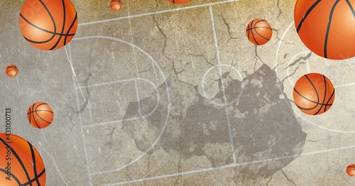 Composition of multiple basketballs in air over basketball court cracked distressed surface