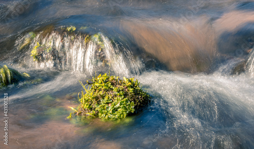 Close up of a river flowing over a stone
