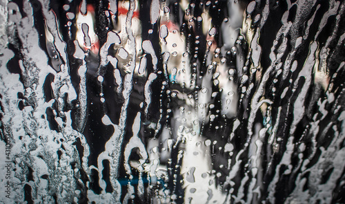 фотографія Background - Going through an automatic car wash - soapy water blowing up window with dark blur outside