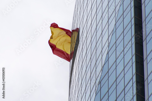 Bandera España tras edificio acristalado