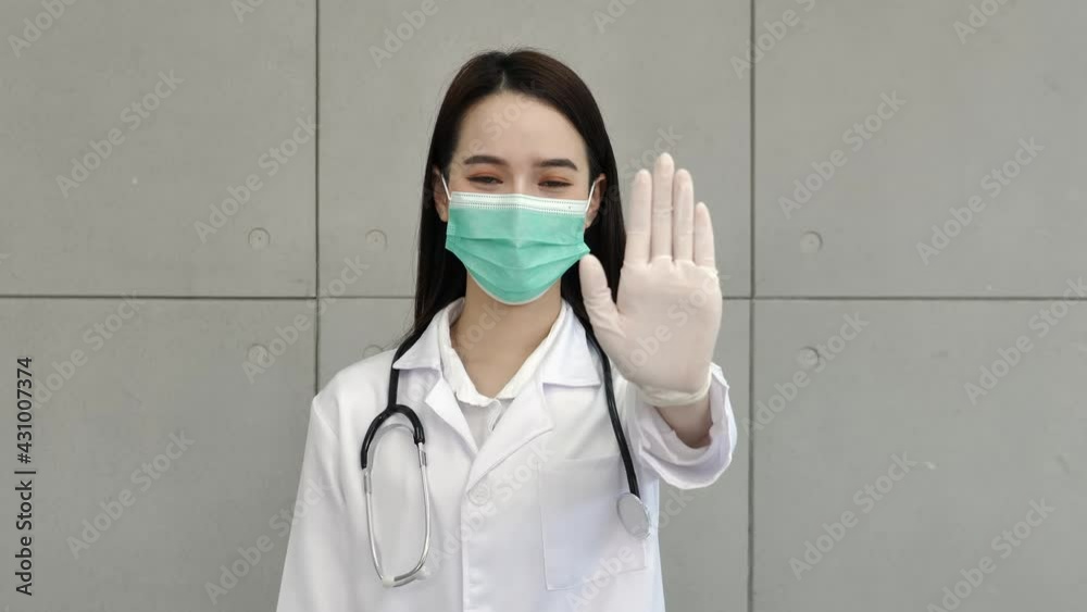 An Asian female doctor or nurse in a uniform and wearing a medical mask