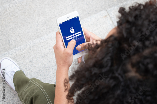 Close up of a girl unrecognizable entering her user a password on her phone. Security Concept.