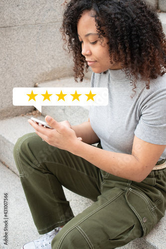 Curly haired girl sitting smiling while rating a experience.