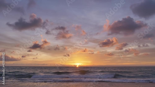 A beautiful reflection of the sunset over the horizon between the sky and the smooth wave, taken at the Hat Mai Khao beach, Phuket Thailand.