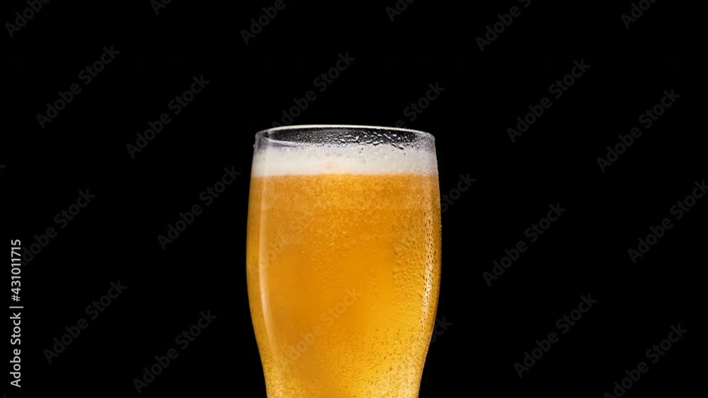 Lager Beer closeup. Cold beer isolated on matte black background. Glass of beer with water drops and bubble Lager Beer closeup. Cold beer isolated on matte black background. Glass of beer with water drops and bubble