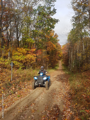 ATV riding in fall forest in Ontario mid October on dirt trails through woodlots