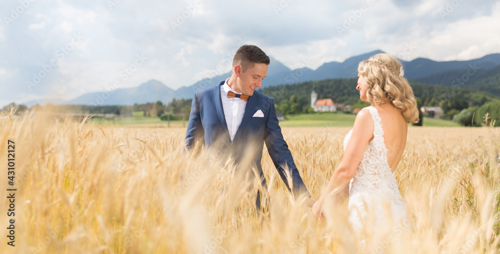 Groom and bride holding hands in wheat field somewhere in Slovenian countryside. Groom and bride holding hands in wheat field somewhere in Slovenian countryside.