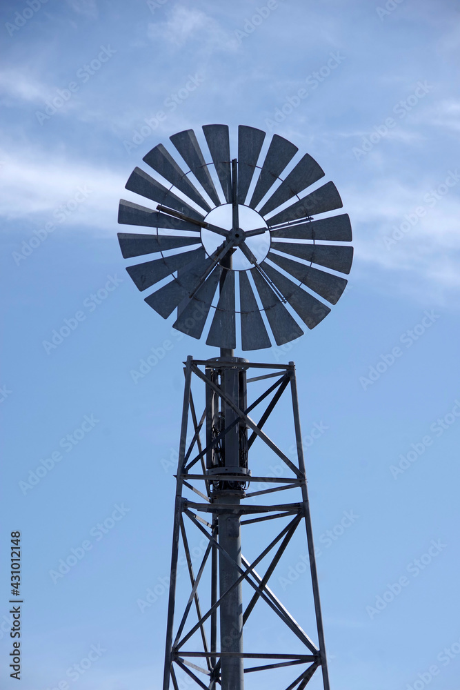 Electric power generating windmill wheel on a metal tower construction Electric power generating windmill wheel on a metal tower construction