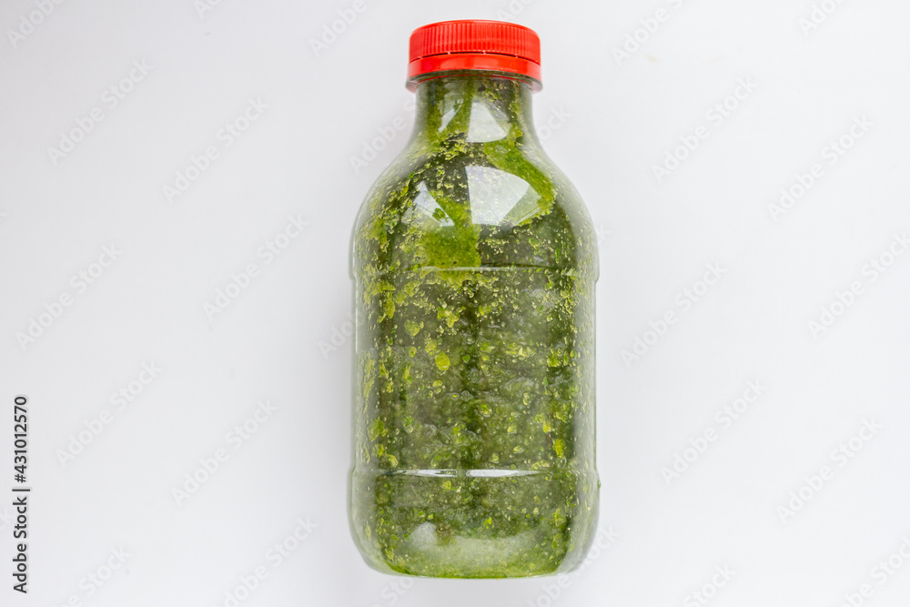 Fototapeta premium Bottle of green smoothie, zucchini and cucumbers on a white background.