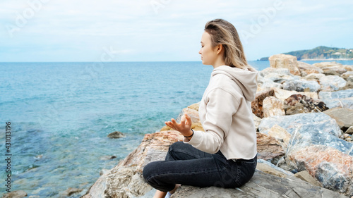 Blonde woman in lotus pose doing breathing pranayama exercise. Outdoor workout. Mindfulness zen spiritual meditation tips. Kundalini yoga. Reiki meditation. Relaxing. Unity with nature © Karyna