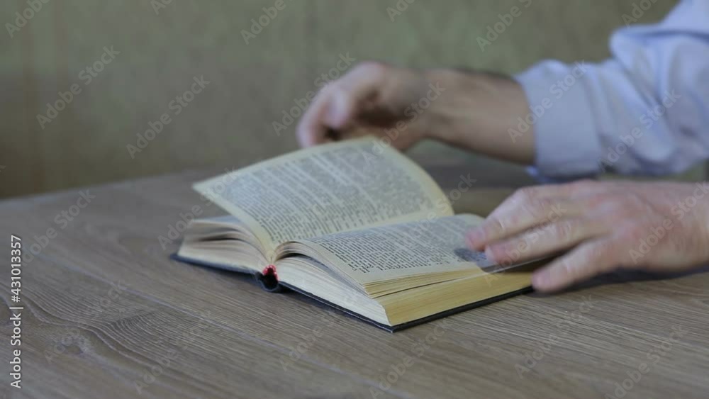 The man is tearing the pages of the book. The man is tearing the pages of the book.