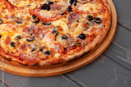 Close up of freshly baked pizza on black wooden table