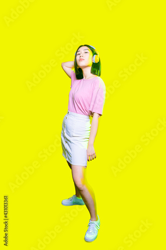 Young confident asian woman posing wearing headphones