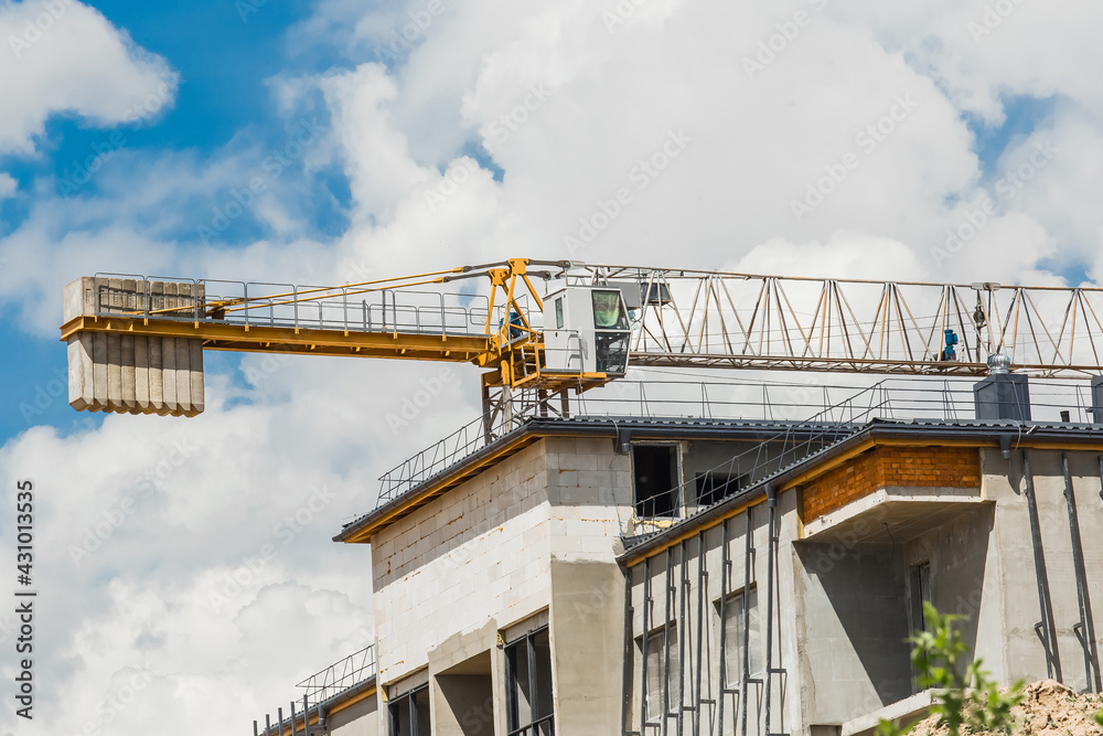 Fototapeta premium Belarus, Minsk - May 28, 2020: Tower crane and urban modern building under construction at a industrial site