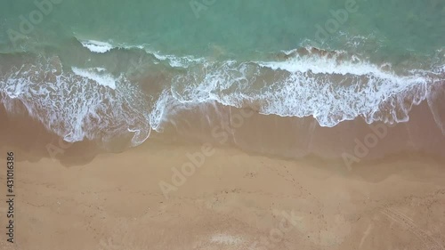 Beautiful 4K tropical beach aerial - a bird's eye view of ocean waves crashing against an empty beach from above, Phuket beach thailand