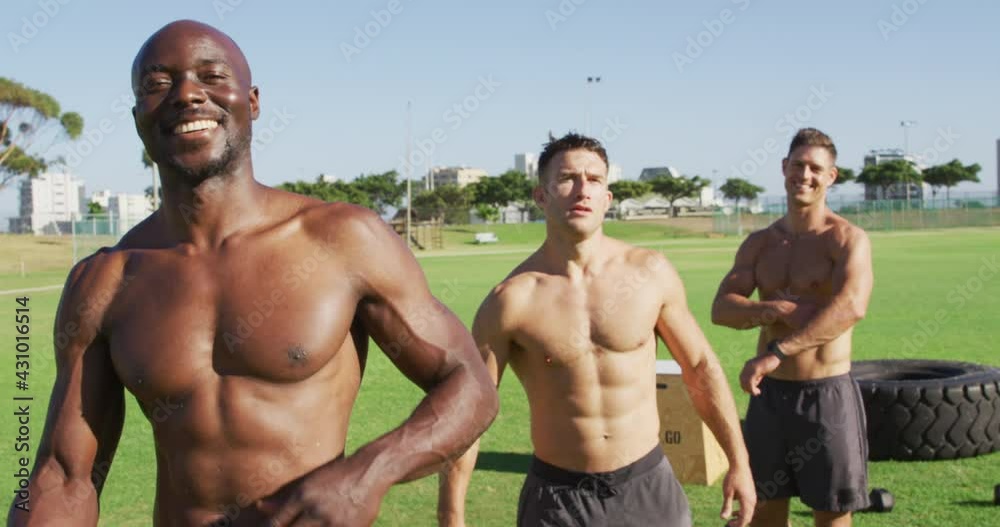 Three shirtless diverse fit men smiling and turning to camera after exercising outdoors Three shirtless diverse fit men smiling and turning to camera after exercising outdoors