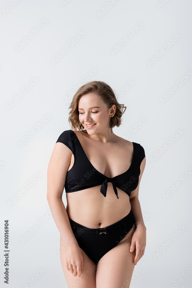 Fototapeta premium happy overweight woman in black swimsuit isolated on white