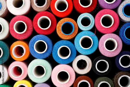 Close up of colored thread coils, thread spools background