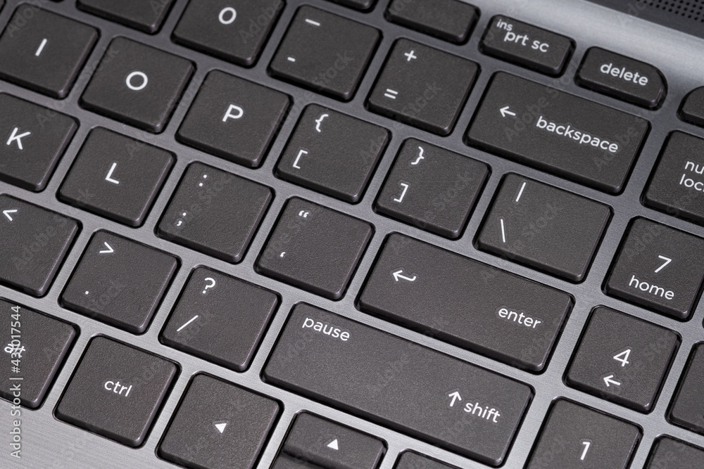 Close up black keyboard of a computer notebook or laptop on focus at enter button, technology background, empty space for text Close up black keyboard of a computer notebook or laptop on focus at enter button, technology background, empty space for text