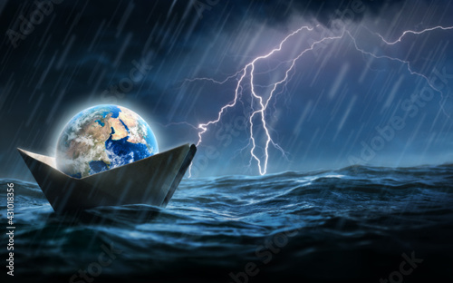 World in a paper boat floating in the ocean in a middle of a storm. Faith despite of world crisis and hardship conceptual theme.
