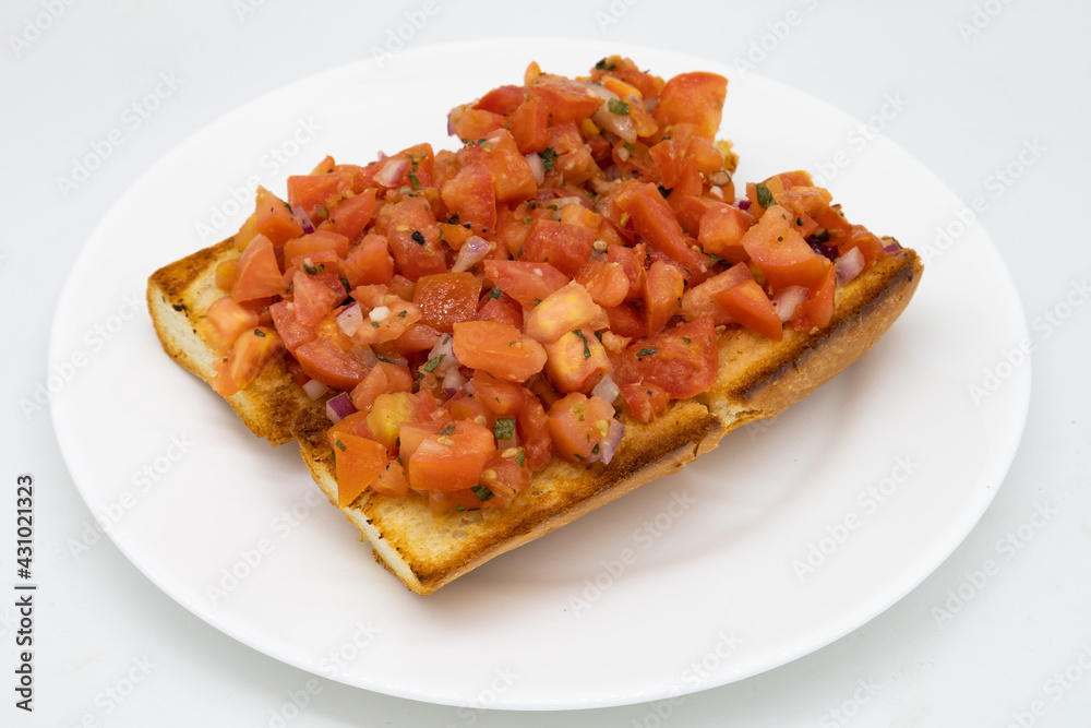Two Large Pieces of Bruschetta on a White Plate Two Large Pieces of Bruschetta on a White Plate