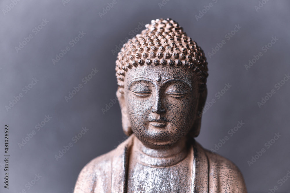 Meditating Buddha Statue on paper background. Close up. 