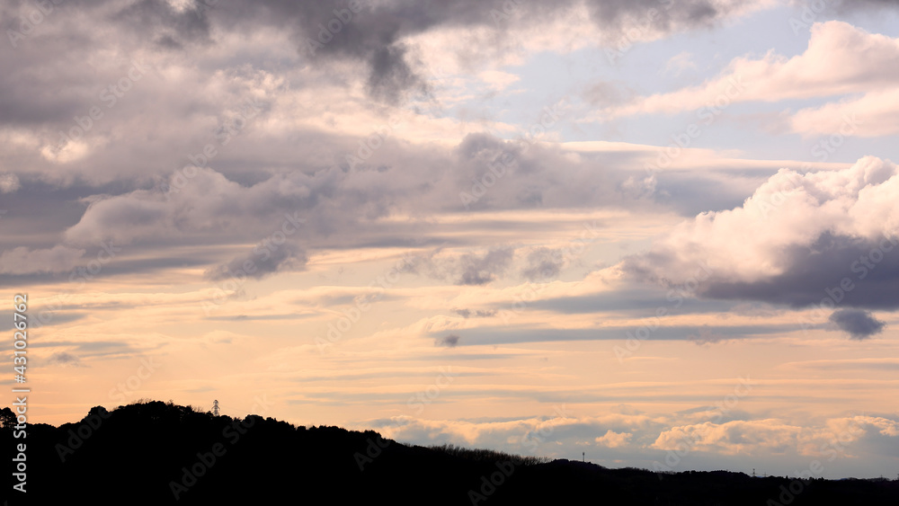 Layers of Evening Clouds with Mountains under Sunset