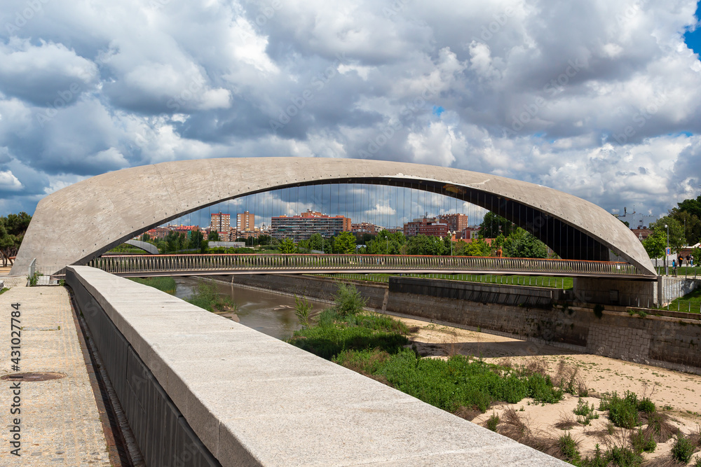 Fototapeta premium Madrid, Spain- April 30, 2021: Bridges over the Manzanares river in Madrid. Constructions next to the river. Urban photo