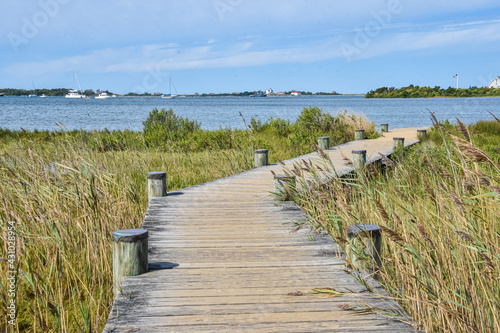 Fototapeta Naklejka Na Ścianę i Meble -  A boardwalk leads to the shore of Great Salt Pond.  Block Island, Rhode Island.  Copy space.