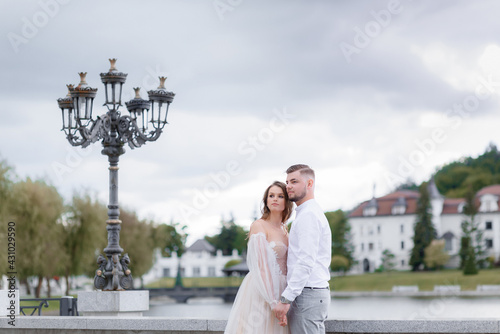 Front view of elegant newlyweds holding hands and looking into the distance. Concept of wedding couple