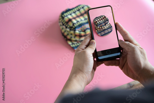 Men take photos of hats for sale online on the Internet.