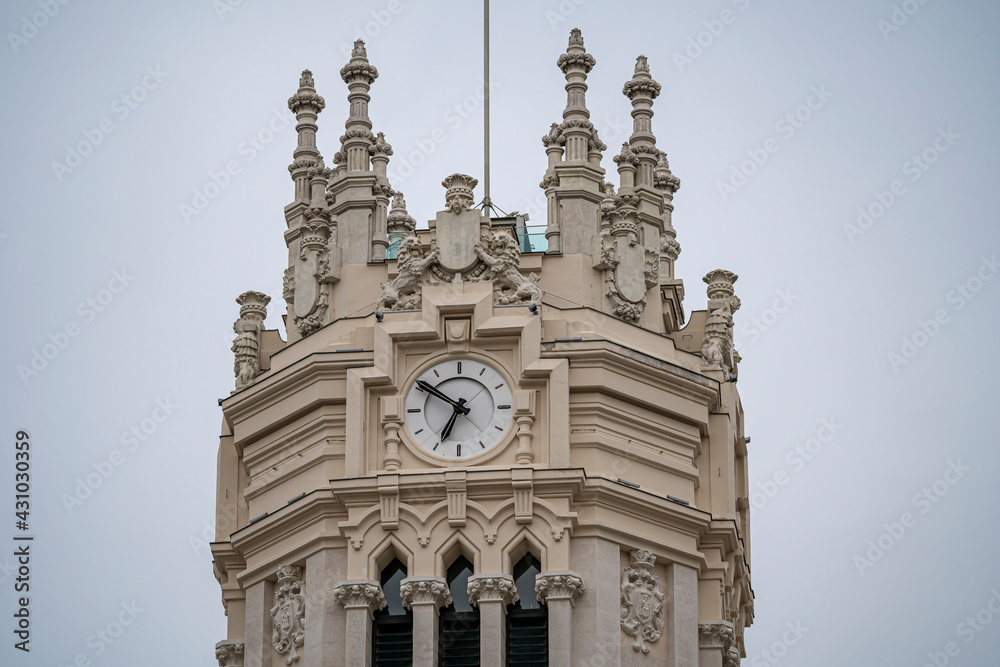 Fototapeta premium Detail photograph of the tower and clock of the Madrid Post Office Palace, seat of the Madrid City Council