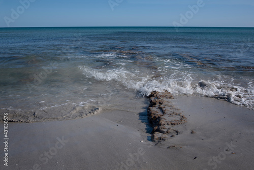 Wallpaper Mural The Mediterranean coast with sand against a blue sky with a ruined jetty made of old stones, some of which protrudes from the waves Torontodigital.ca