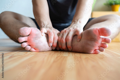 The man sitting in the room grabbing his feet after the gout flared photo