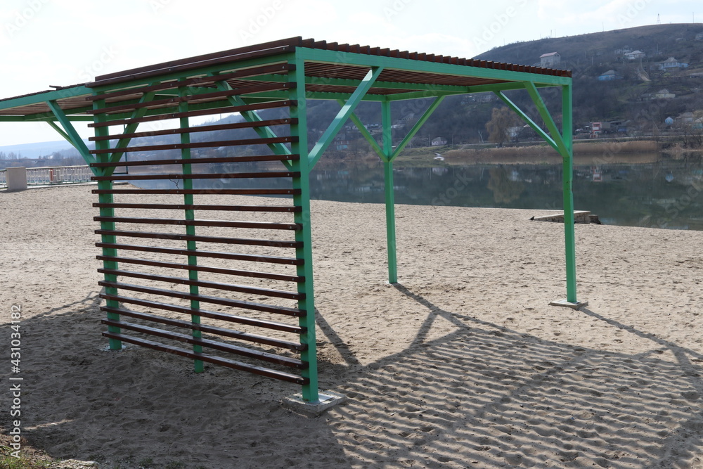 Sunshade on the beach. Park area on the river bank. River beach. A place for people to relax Sunshade on the beach. Park area on the river bank. River beach. A place for people to relax