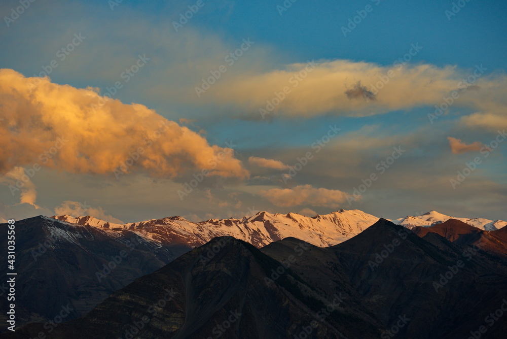 Russia. North-Eastern Caucasus, Republic of Dagestan. Shrouded in clouds and illuminated by the morning sun, the snow-capped peaks of the mountains near the city of Agwali.