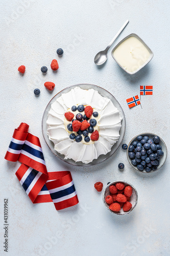 Pavlova cake for Norwegian Independence day with Norwegian flag and raspberries and blueberries