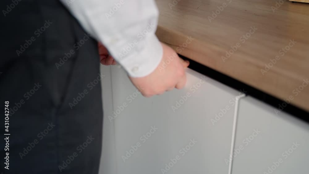 The client chooses a dishwasher. Opening the white built-in dishwasher door The client chooses a dishwasher. Opening the white built-in dishwasher door