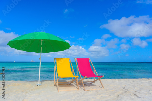 Fototapeta Naklejka Na Ścianę i Meble -  Colorful beach lounge chairs and umbrella at the beach
