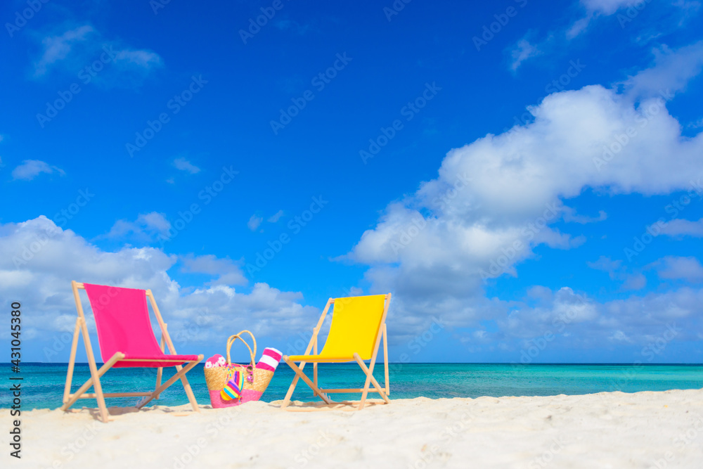 Colorful beach lounge chairs and beach bag at the beach Colorful beach lounge chairs and beach bag at the beach