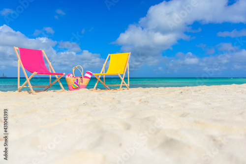 Fototapeta Naklejka Na Ścianę i Meble -  Colorful beach lounge chairs and beach bag at the beach