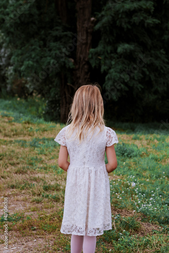 little girl in white dress in the forest